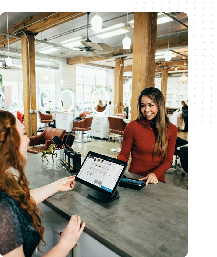 Hair salon with wooden beams and a receptionist helping a customer